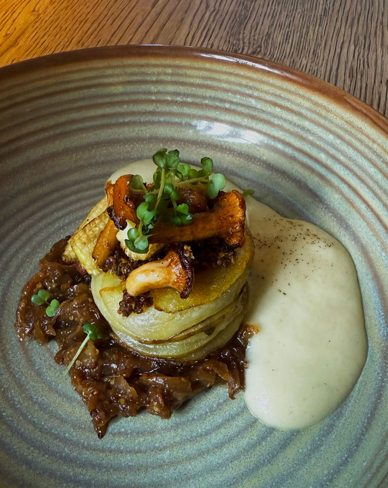 Main course of layered roast potatoes with smoked caramelised onions, grilled chanterelle and baby corn at Bonboon restaurant