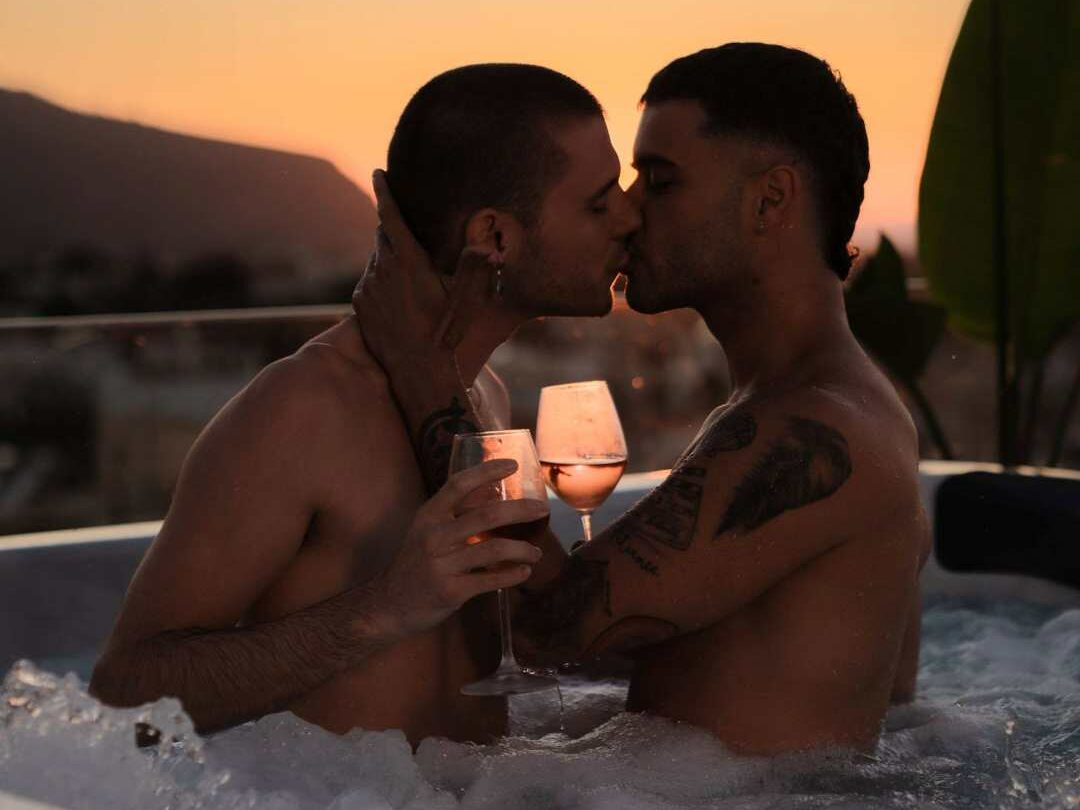 Two men kissing a jacuzzi