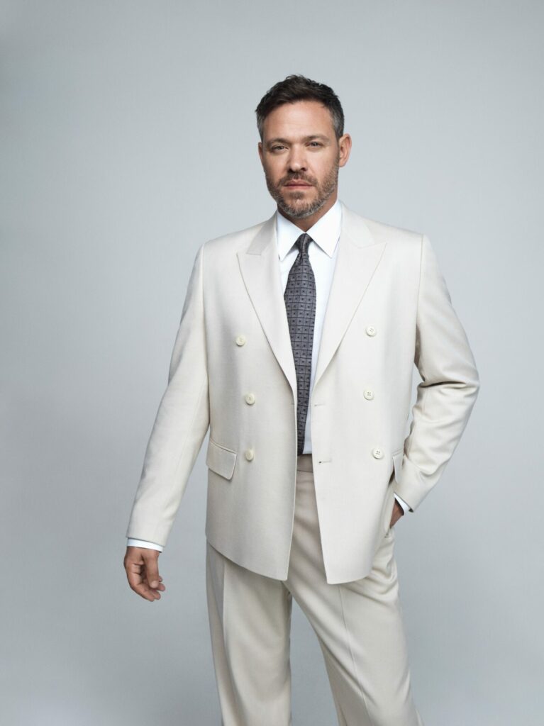 a head and shoulders shot of Will in a white suit and shiny with white background
